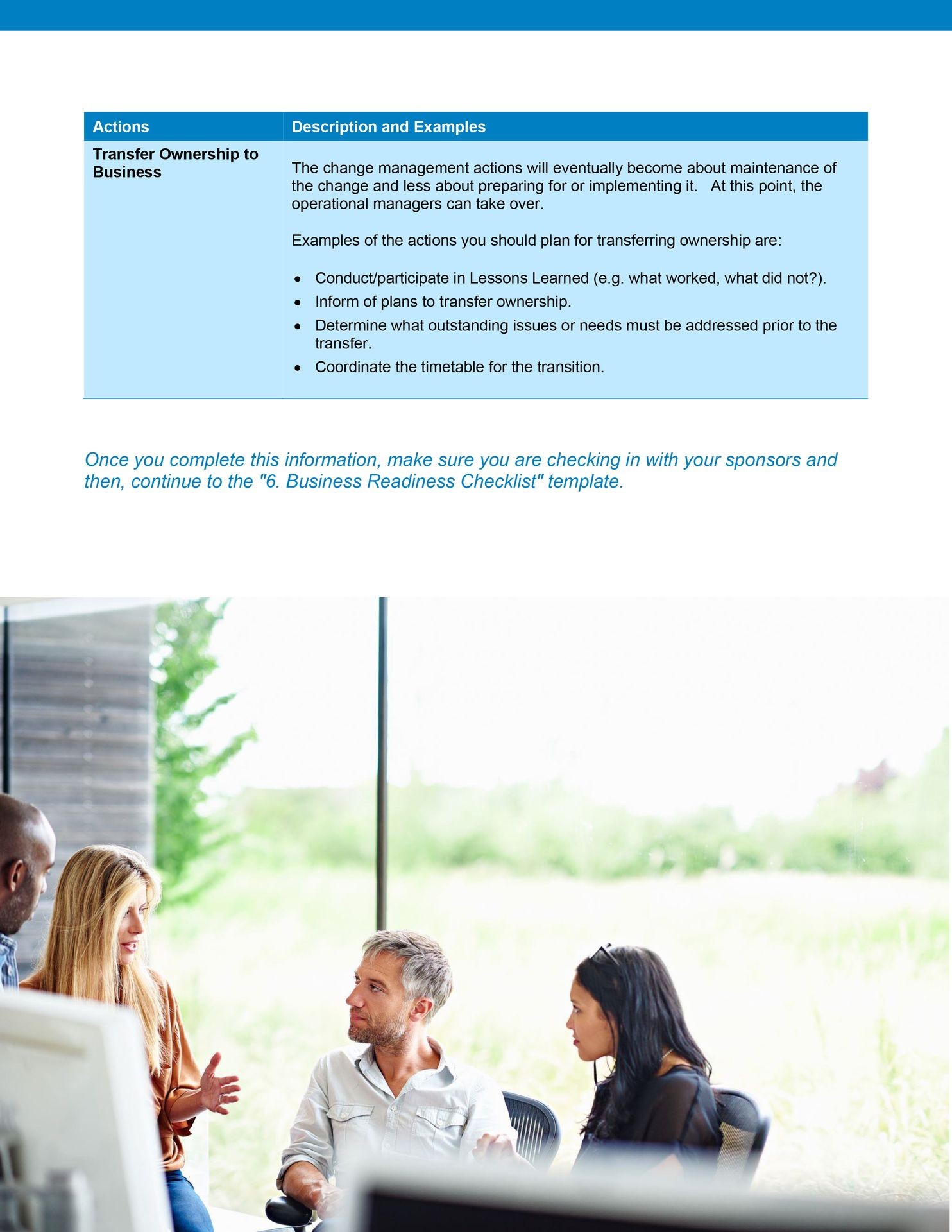 Business meeting in a bright room with four people discussing near a window overlooking greenery.