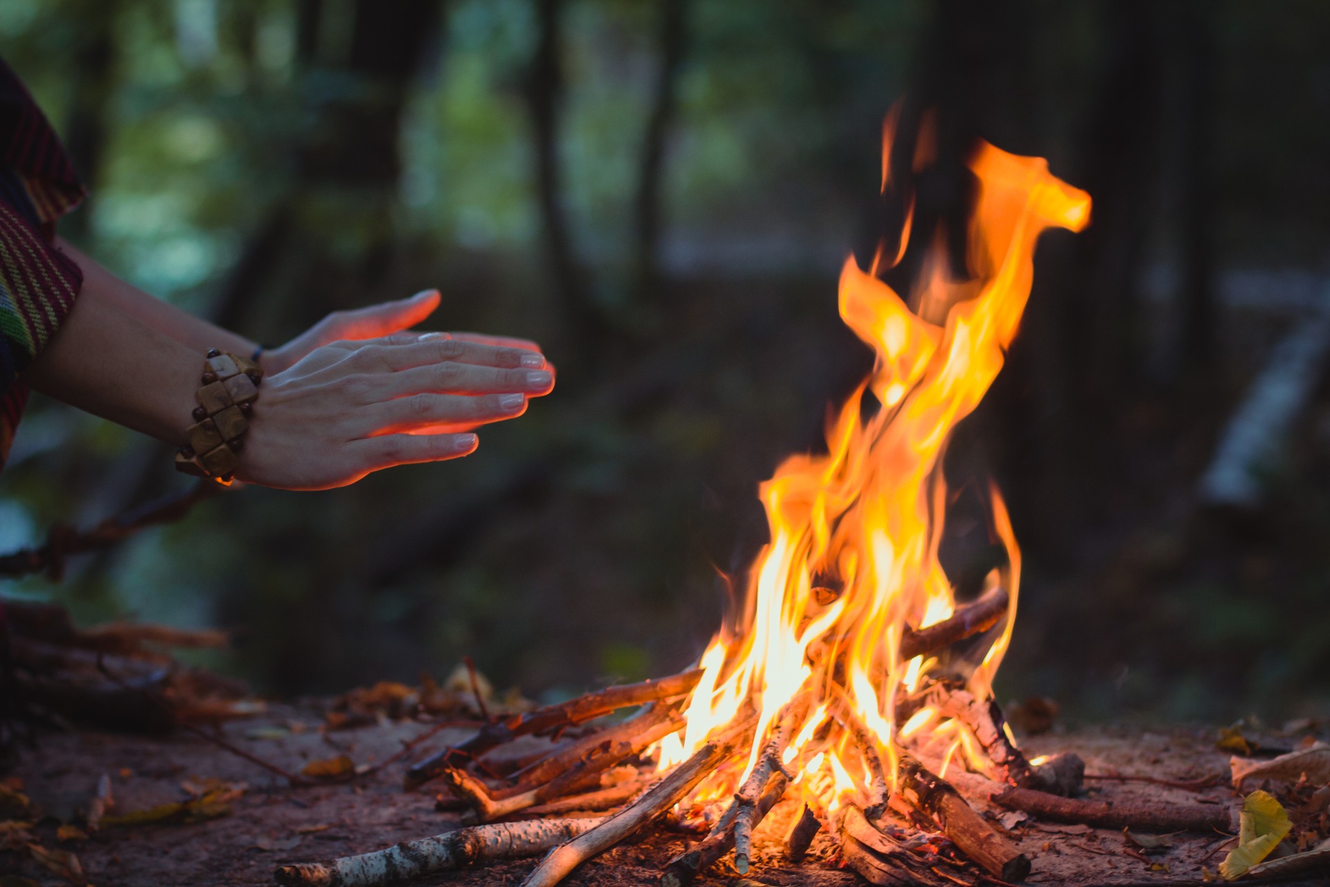 Close up hands warming over campfire concept photo