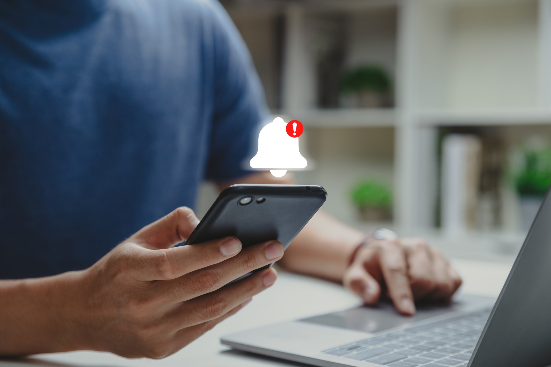 Young man using phone with danger alert.